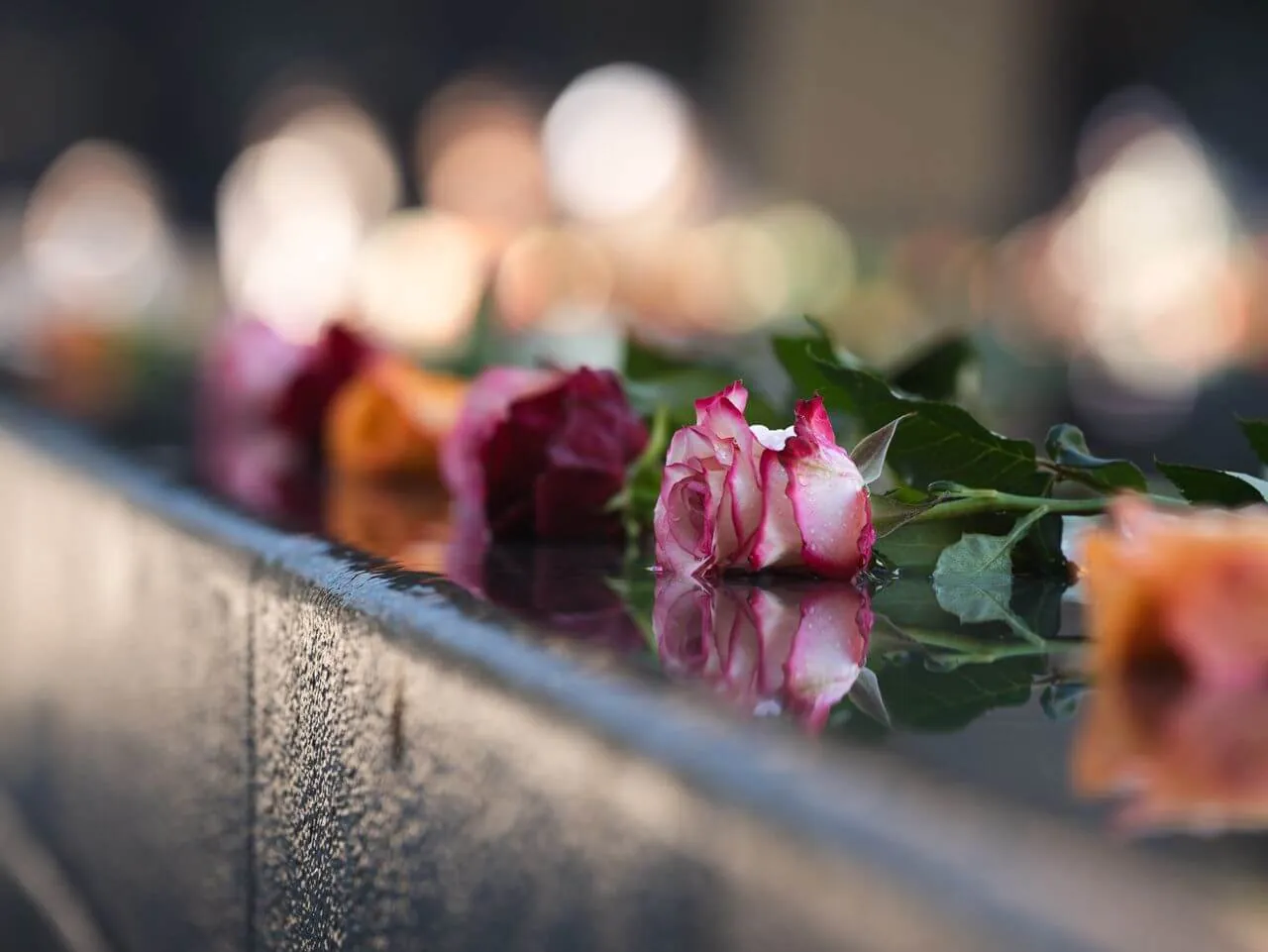 Blumen und sanft leuchtende Kerzen zum Gedenken