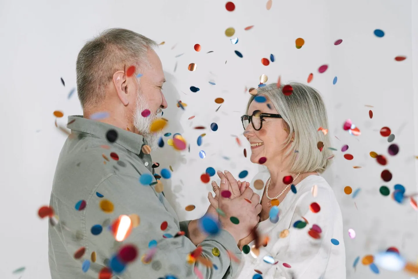 An older couple celebrating together with colorful confetti