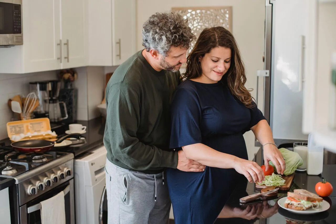 Un matrimonio preparando una comida en su cocina