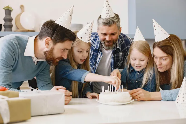 Familie und Freunde versammeln sich um einen Geburtstagskuchen